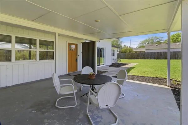 a backyard of a house with table and chairs