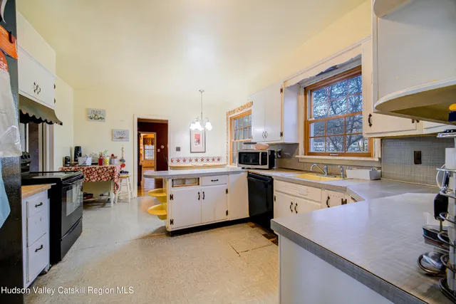 a kitchen with stainless steel appliances sink stove refrigerator and cabinets