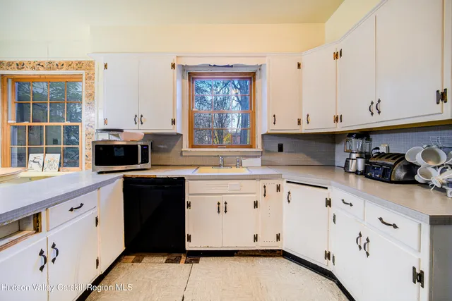 a kitchen with granite countertop white cabinets and window