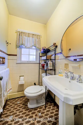 a bathroom with a sink a toilet and a mirror