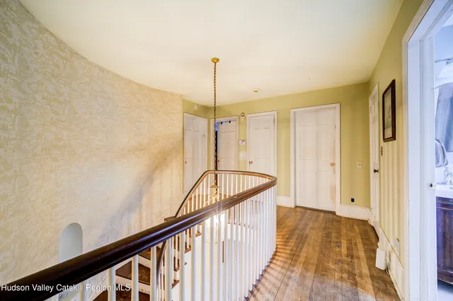a view of a hallway with wooden floor and staircase