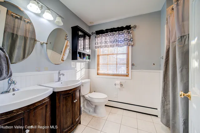 a bathroom with a double vanity sink mirror and toilet