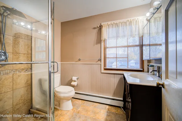 a bathroom with a sink a toilet and a shower