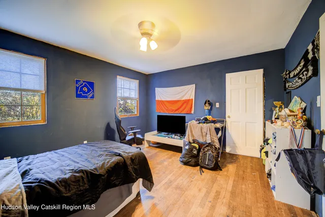 a bedroom with a bed and wooden floor