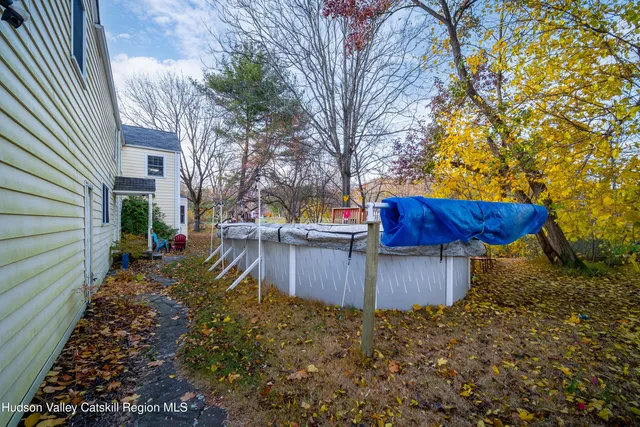 a view of a backyard with wooden fence and large trees