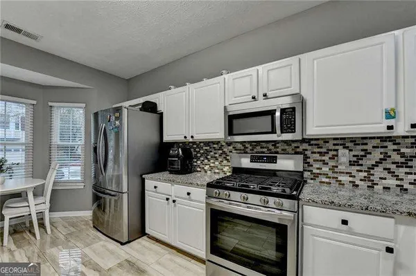 a bathroom with a granite countertop sink and a white stove