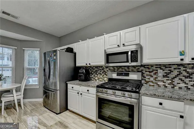 a bathroom with a granite countertop sink and a white stove