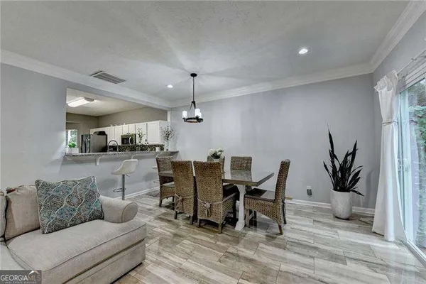 a dining room with furniture potted plants and wooden floor