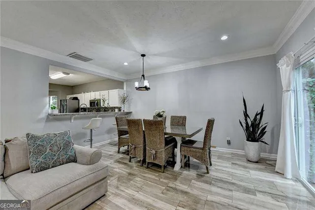 a dining room with furniture potted plants and wooden floor