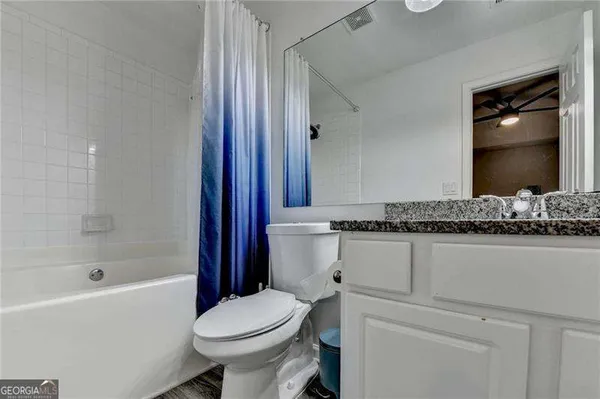 a bedroom with a bed and a flat tv screen on dresser