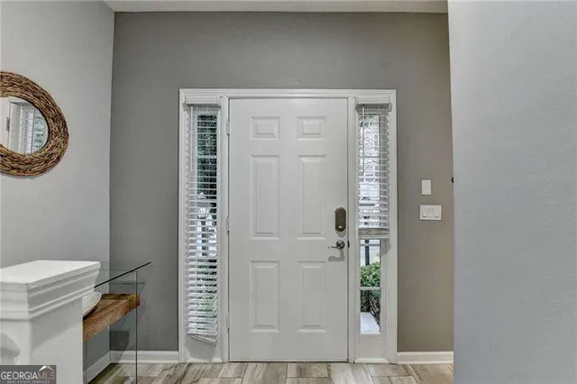 a kitchen with stainless steel appliances a refrigerator a stove a sink dishwasher a dining table and chairs with wooden floor