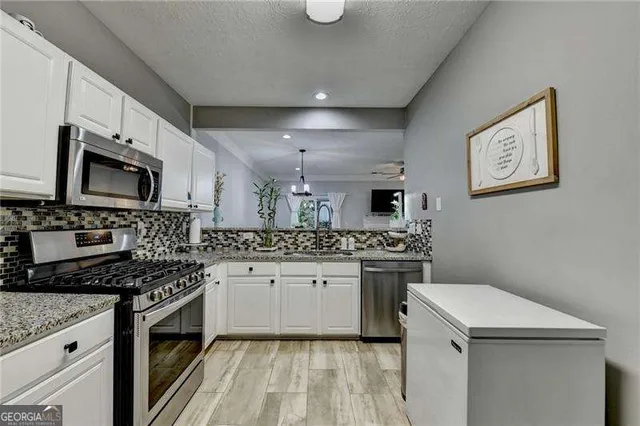 a kitchen with granite countertop a sink a stove and cabinets