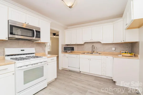 a kitchen with stainless steel appliances white cabinets and stove top oven