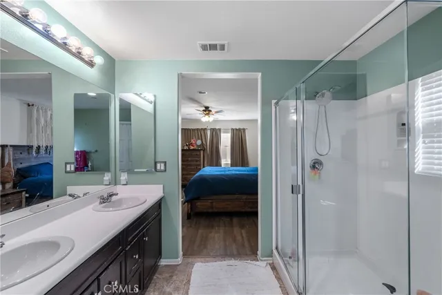 a en suite bathroom with a double vanity sink mirror and shower