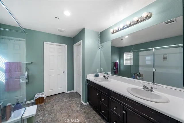 a spacious bathroom with double vanity and a mirror