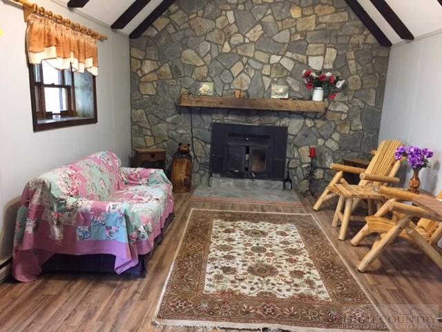 332 Claude Dickson Road Lansing, NC 28643 - Photo 8 of 18 a bedroom with a bed and a fireplace