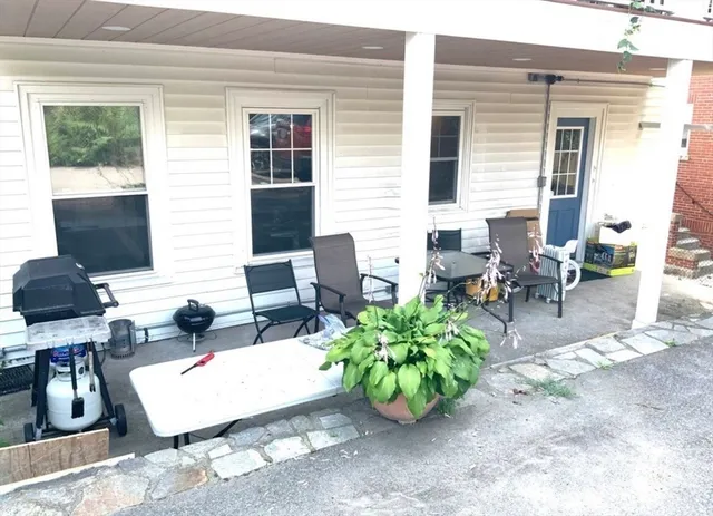 a view of a patio with chairs and potted plants