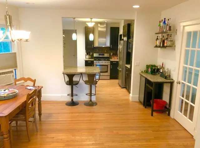 a kitchen with stainless steel appliances refrigerator dining table and chairs