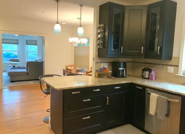 a kitchen with granite countertop a sink cabinets and wooden floor