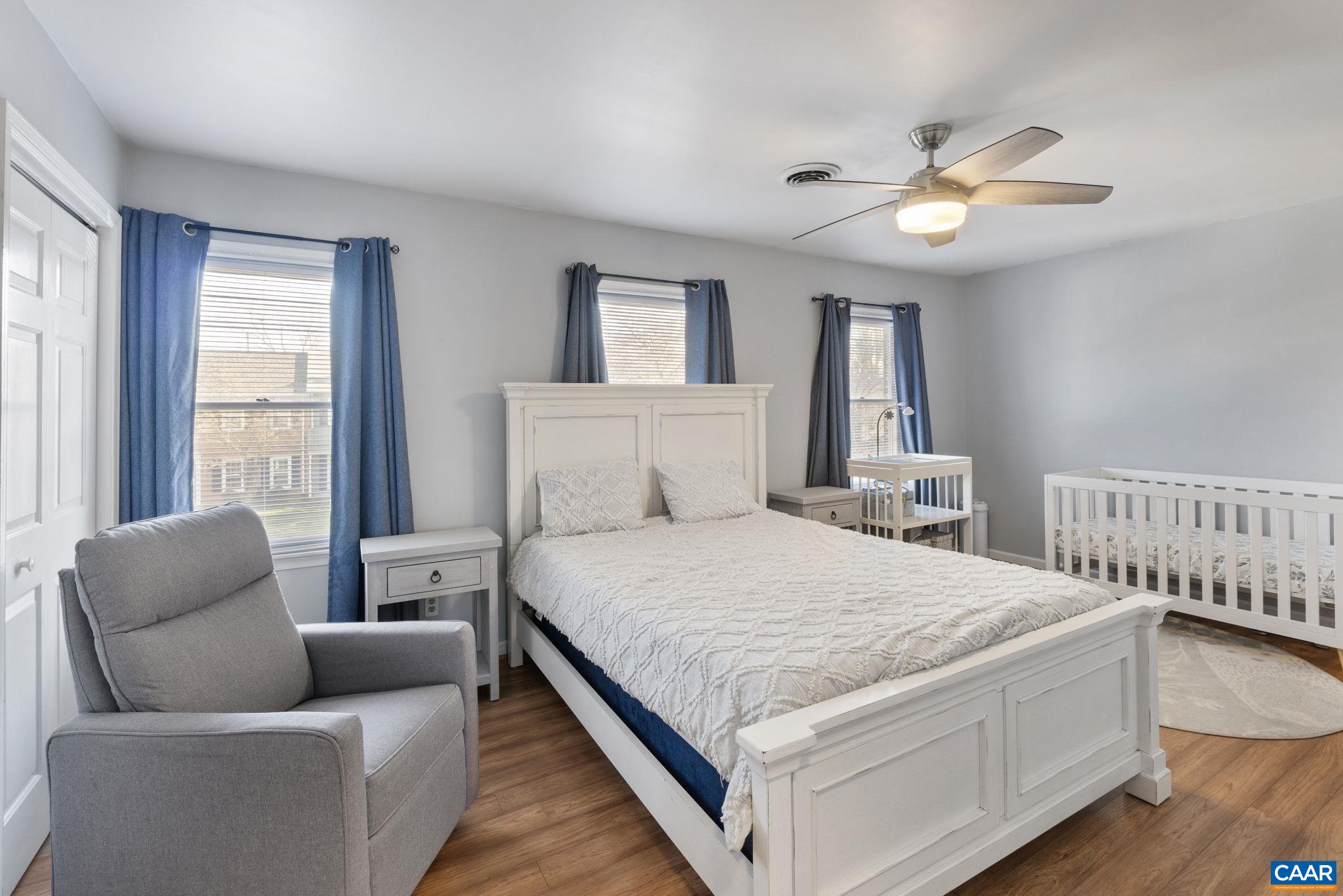 1540 Minor Ridge Court Charlottesville, VA 22901 - Photo 14 of 26 a bedroom with a large bed couch and windows