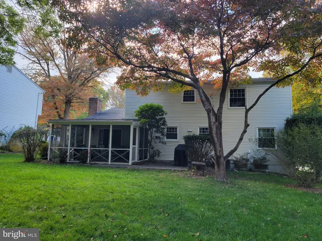 a view of a house with backyard garden and a tree