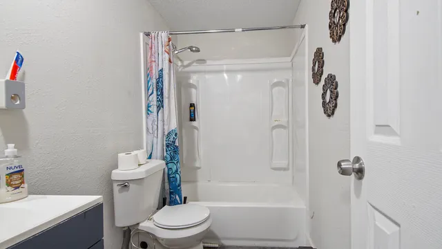 a bathroom with a shower a toilet and sink