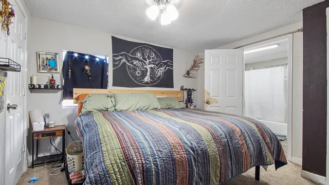 a bedroom with a bed and painting on the wall