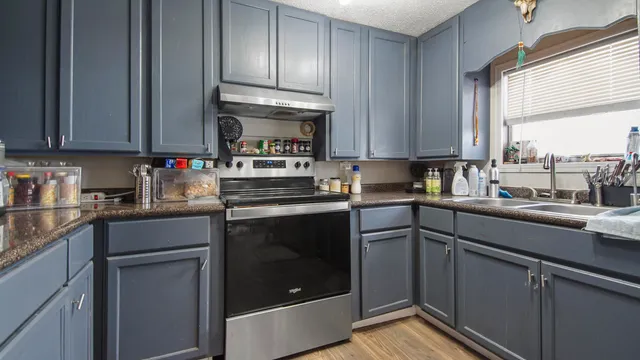 a kitchen with stainless steel appliances granite countertop a stove a sink and a refrigerator