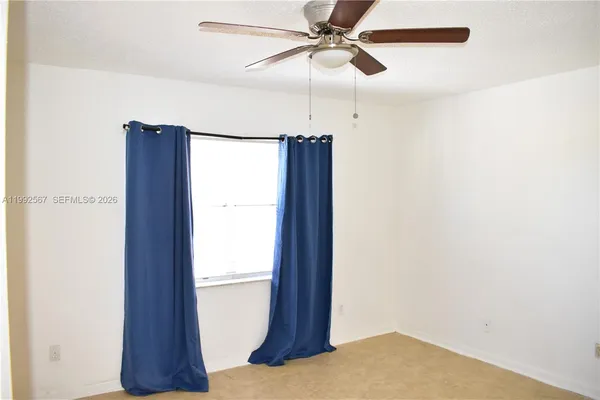 a view of a room with a ceiling fan and a window