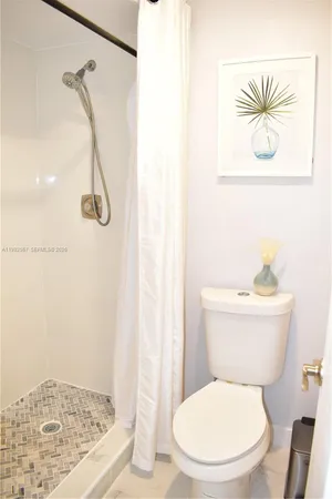 a white toilet sitting next to a shower