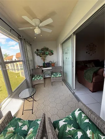 a living room with furniture a rug and a floor to ceiling window