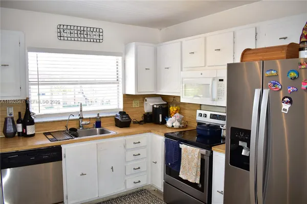 a kitchen with stainless steel appliances a refrigerator sink and cabinets