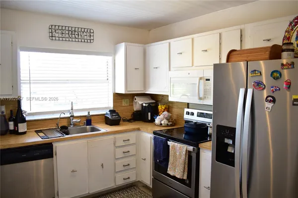 a kitchen with stainless steel appliances a refrigerator sink and cabinets