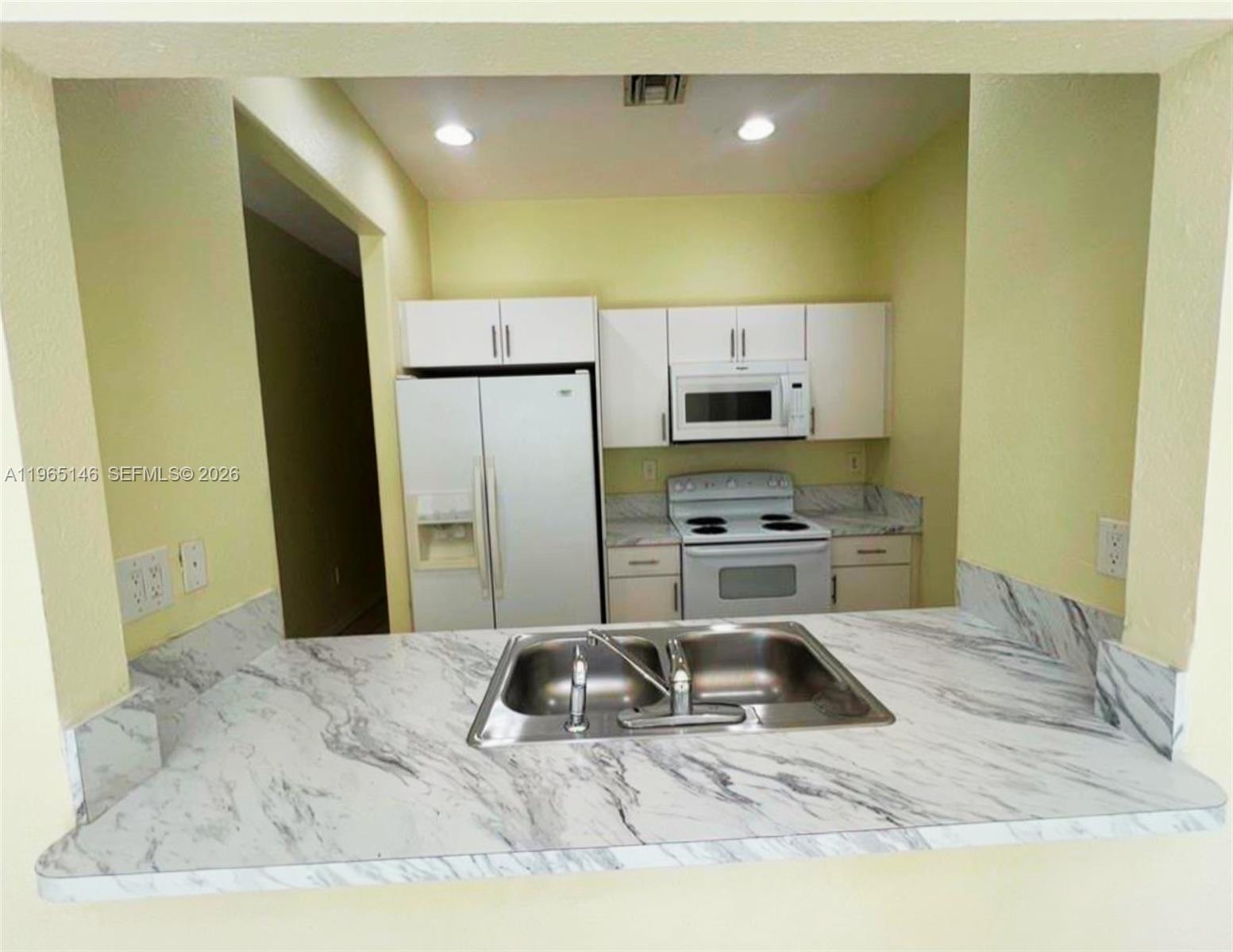 23712 Southwest 110th Avenue Homestead, FL 33032 - Photo 4 of 7 a kitchen with a refrigerator a microwave a sink and a stove