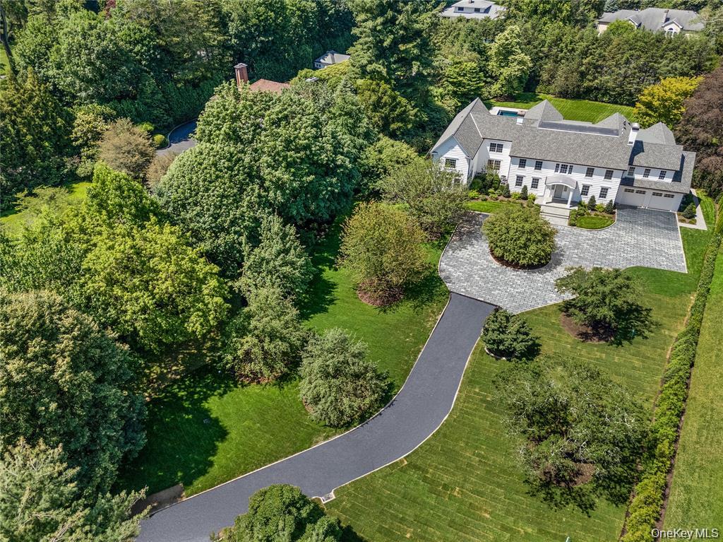 42 Mamaroneck Road Scarsdale, NY 10583 - Photo 45 of 47 A sweeping aerial view highlights the estate's impressive approach, expansive circular driveway, and picturesque setting surrounded by mature specimen trees.