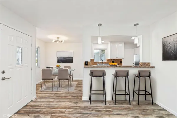 a living room with furniture a flat screen tv and kitchen view
