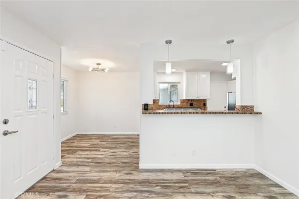 a view of a kitchen with kitchen island a sink wooden floor and a refrigerator
