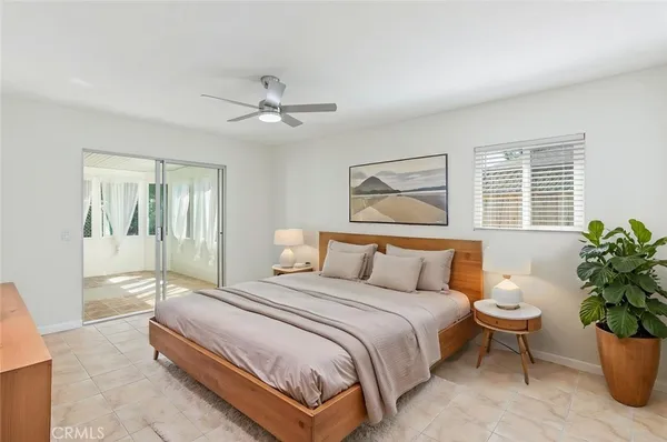 a bedroom with a large bed and a potted plant