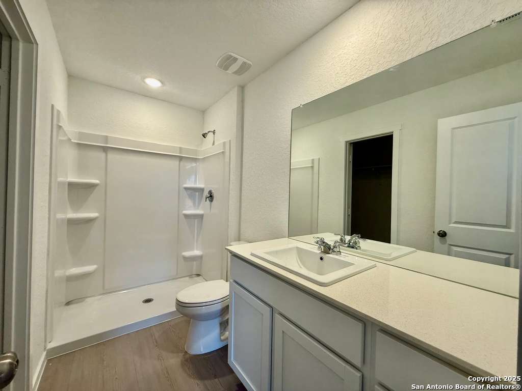 10319 Munoz Manor San Antonio, TX 78214 - Photo 12 of 13 a bathroom with a sink a toilet and shower