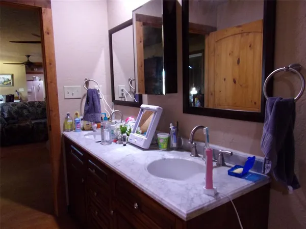 a bathroom with a granite countertop sink and a mirror