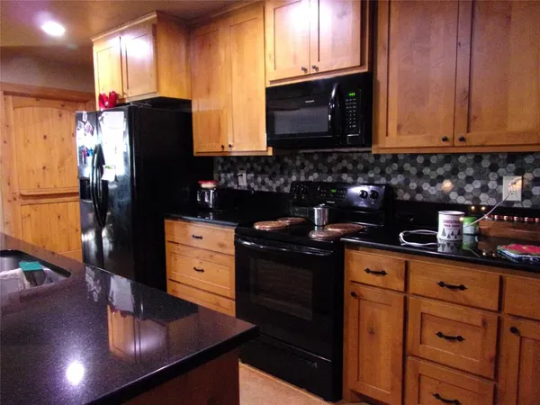 a kitchen with appliances a sink cabinets and a window