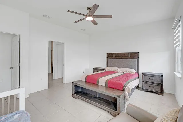 a bedroom with a bed and a ceiling fan