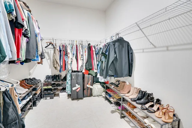 a view of walk in closet with clothes