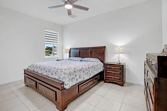 a bed sitting in a bedroom next to a window with a chandelier