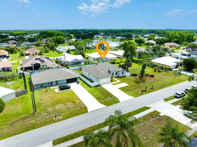an aerial view of residential houses with outdoor space and trees