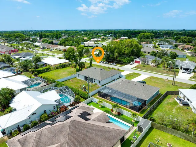 an aerial view of a house with a swimming pool patio and outdoor seating