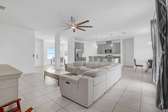 a living room with furniture and a view of kitchen