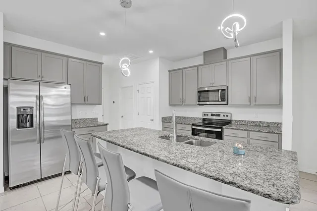 a kitchen with stainless steel appliances granite countertop a sink a stove a microwave and cabinets