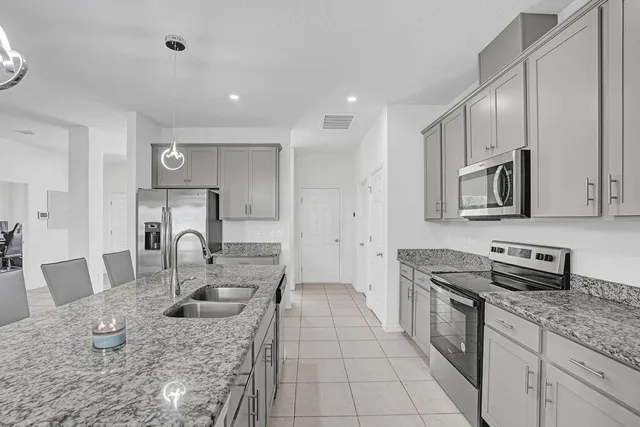 a kitchen with stainless steel appliances granite countertop a sink stove and refrigerator