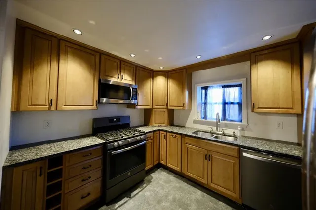 a kitchen with granite countertop stainless steel appliances and wooden cabinets
